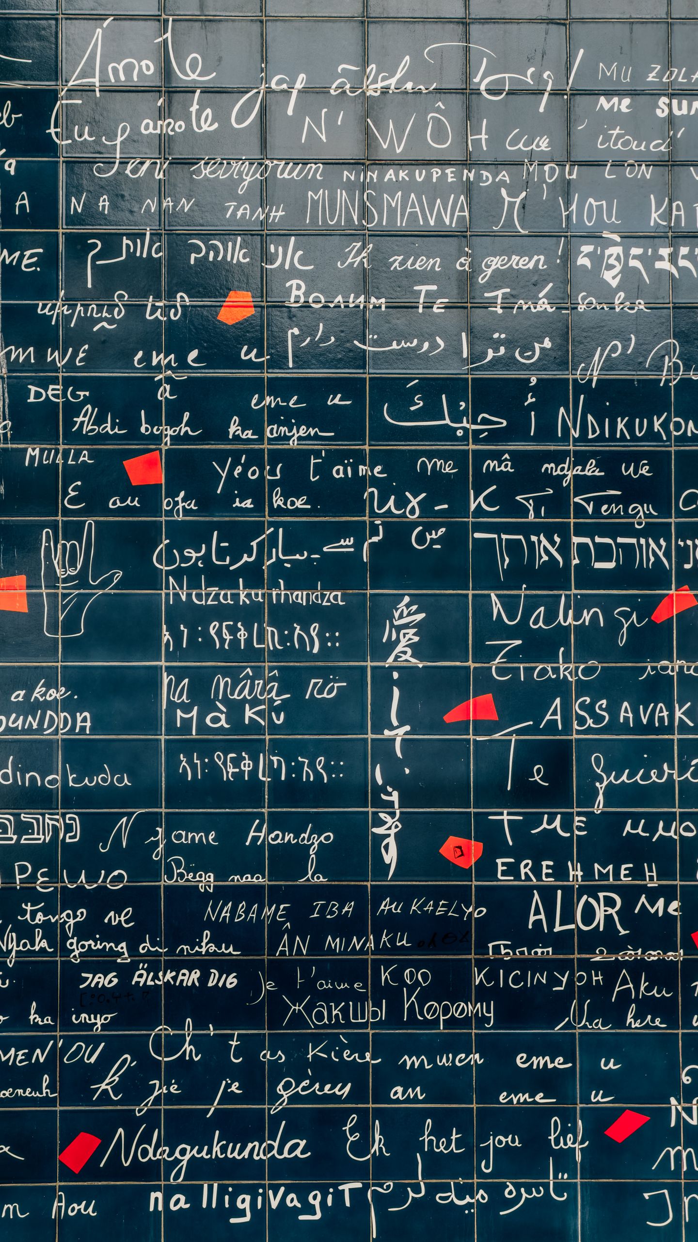 The Love Wall in Montmartre, Paris, displaying 'I Love You' in multiple languages on blue tiles.